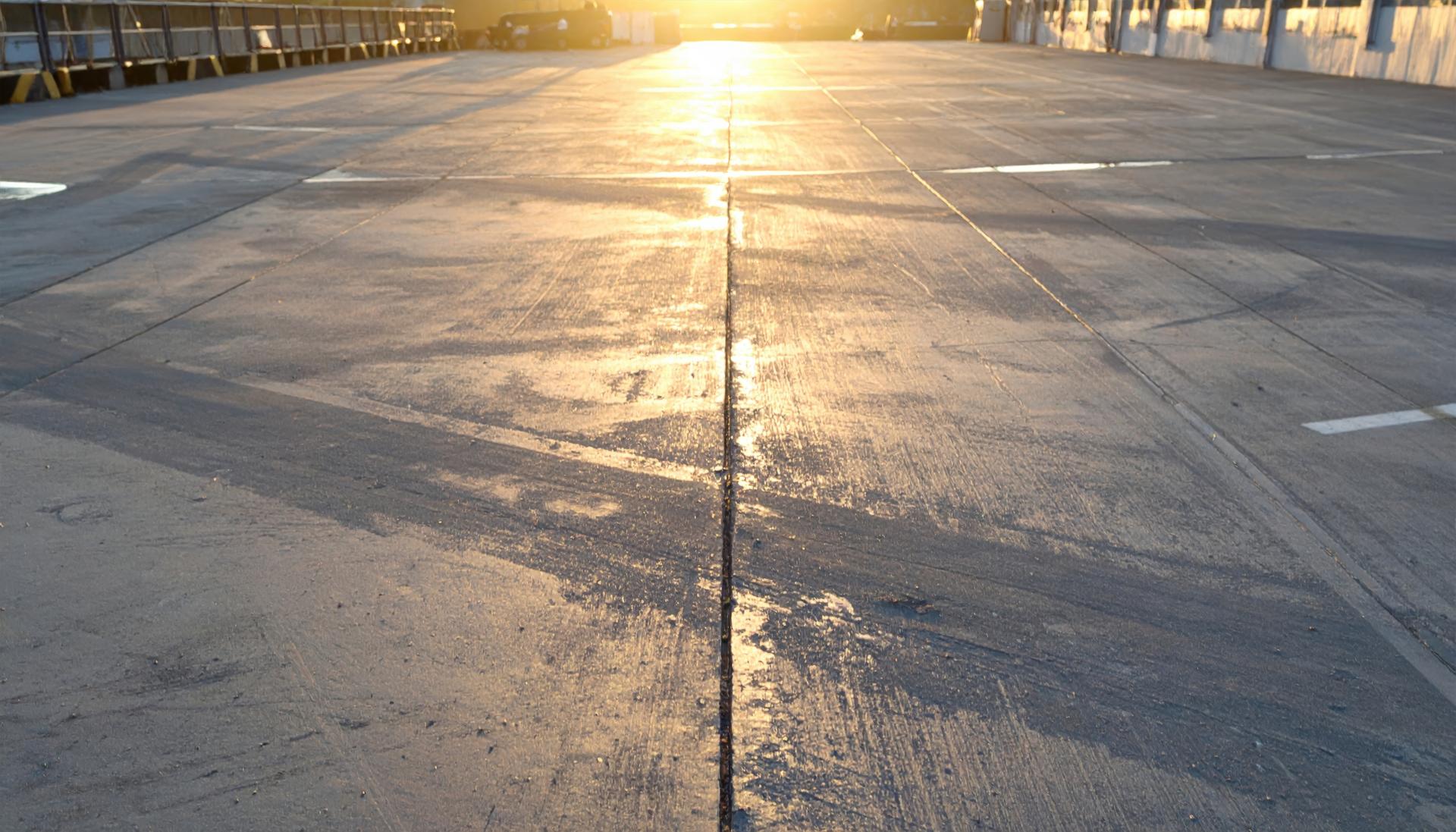 The sun is setting in the sky over street with stop sign.